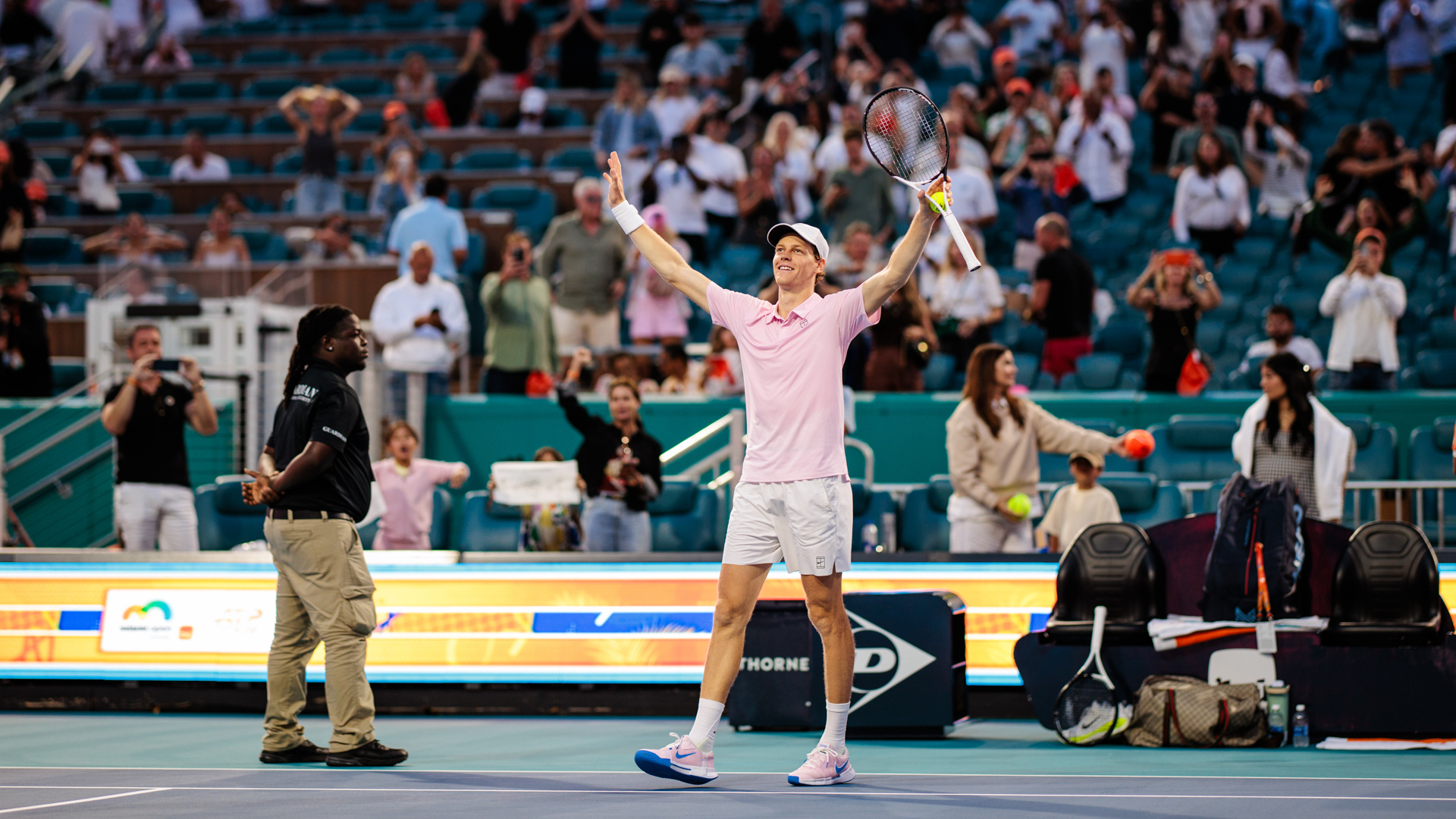 A player raising his arms in celebration after match point