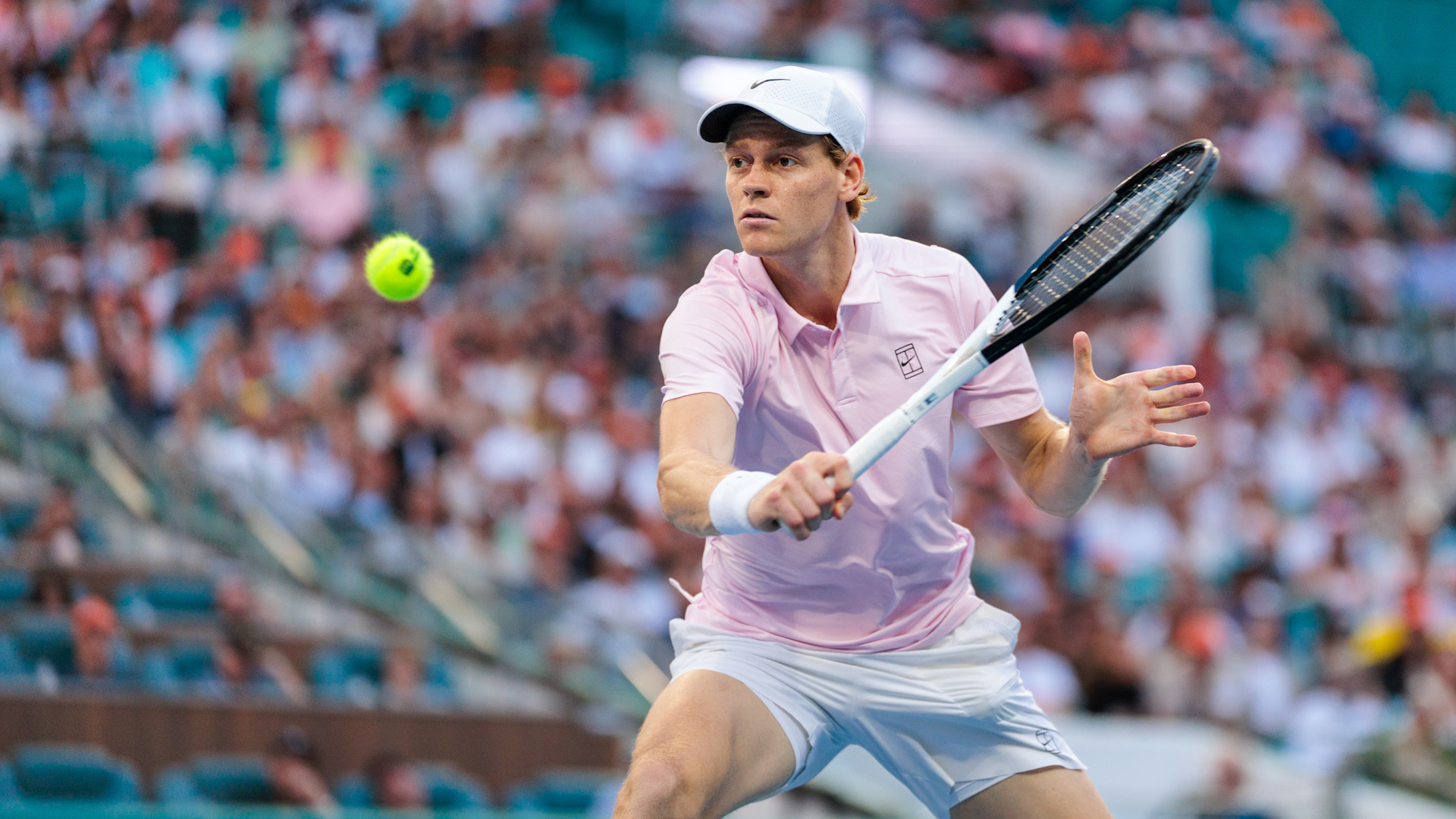 A player striking a forehand in front of the packed stands