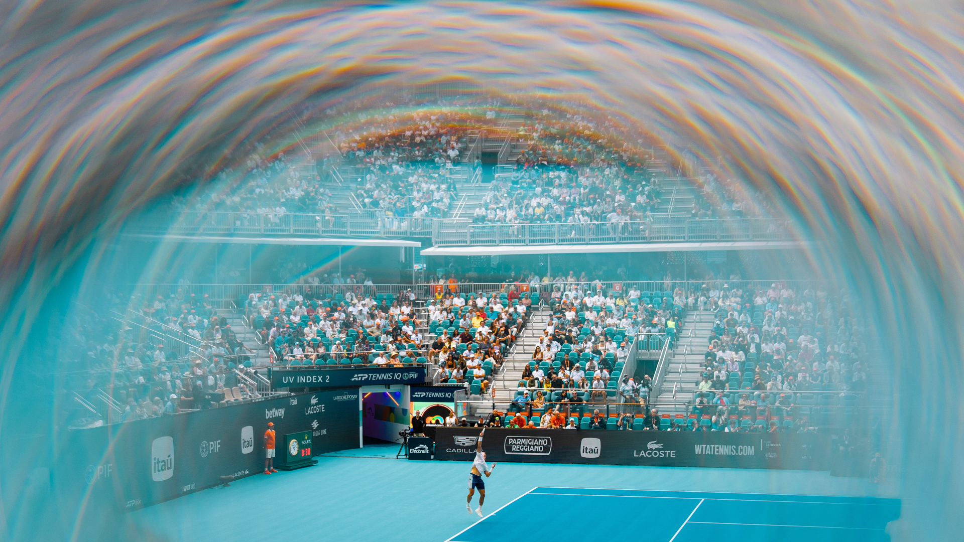 The crowd watches a serve under the lights at Hard Rock Stadium